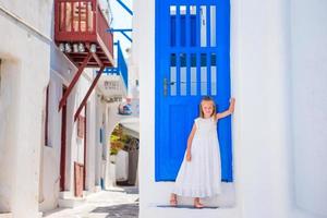 adorabile poco ragazza a strada di tipico greco tradizionale villaggio su mykonos isola, nel Grecia foto