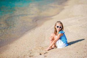 adorabile bambina divertirsi in spiaggia tropicale durante le vacanze foto