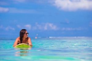 giovane surfer donna fare surf durante spiaggia vacanza foto