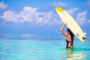 bella donna surfista che pratica il surfing durante le vacanze estive foto