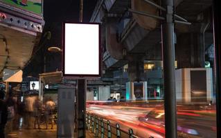 cartellone bianco con copia spazio accanto alla strada di notte foto