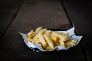 gustose patatine fritte sul fondo della tavola in legno foto