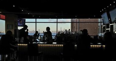 silhouette di persone all'interno di un bar foto