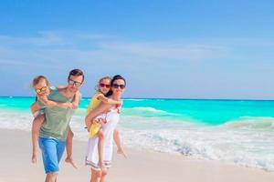 giovane famiglia su vacanza avere un' lotto di divertimento su il spiaggia foto