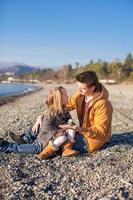 giovane padre e poco ragazza a il spiaggia su un' soleggiato inverno giorno foto