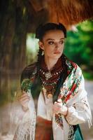 modello in un vestito ucraino posa nel parco