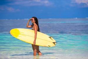 bella donna surfista che pratica il surfing durante le vacanze estive foto