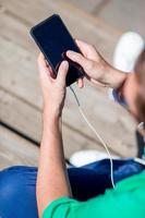 avvicinamento di maschio mani è Tenere cellulare all'aperto su il strada. uomo utilizzando mobile smartphone. foto