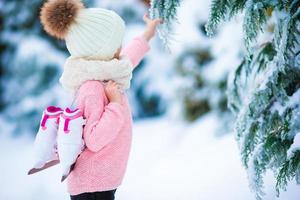 adorabile poco ragazza andando per pattinare nel caldo inverno neve giorno all'aperto foto