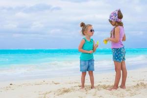 poco adorabile ragazze su bianca tropicale spiaggia foto