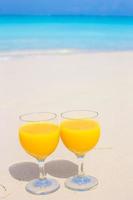 avvicinamento di Due bicchieri su tropicale bianca spiaggia foto