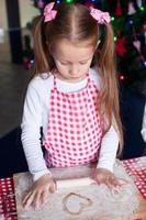 poco contento ragazza con rotolamento perno cottura al forno Pan di zenzero biscotti per Natale foto