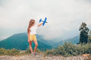 bellissimo contento poco ragazza nel montagne nel il sfondo di nebbia foto