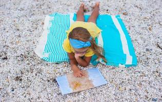 adorabile poco ragazza con carta geografica trova il modo su tropicale spiaggia vacanza foto
