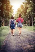 due ragazze che camminano lungo una strada forestale in natura foto