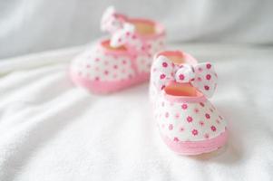 scarpe neonato sulla biancheria da letto bianca foto