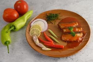 insalata di sardine piccanti su un piatto di legno foto