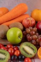 primo piano di kiwi, uva, mele, carote e pomodori foto