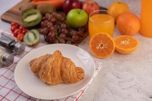 croissant con contorni di frutta a colazione foto