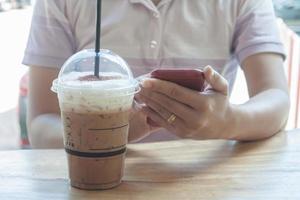 persona in possesso di un telefono con un frappe foto