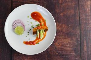 sarde con salsa di pomodoro su un piatto bianco foto