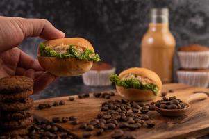 hamburger con chicchi di caffè su una lastra di legno marrone