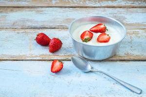 yogurt alla fragola su un tavolo di legno foto