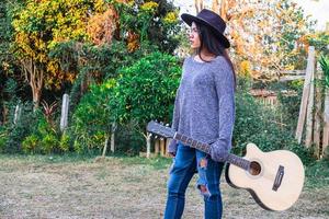 donna che cammina con una chitarra foto