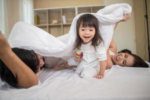 bambino felice con i genitori che giocano foto