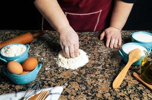 primo piano di una persona che fa la pasta foto