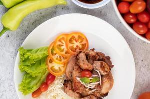 cotoletta di maiale alla griglia con pomodori e insalata foto