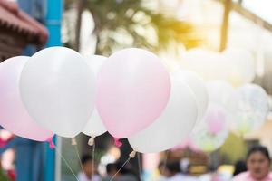 palloncino rosa e bianco con luce soffusa. congratulazioni. foto