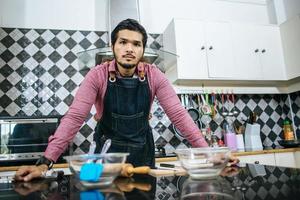 bell'uomo preparare il cibo in cucina foto