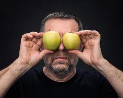 di mezza età uomo con un' verde mele foto