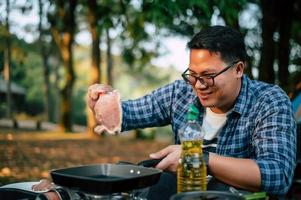 ritratto di asiatico viaggiatore uomo bicchieri Maiale bistecca frittura foto