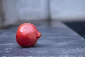 maturo rosso Melograno su un' pietra tavolo. vicino su foto