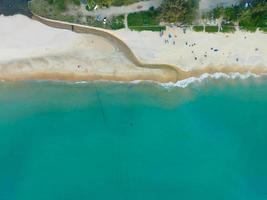 aereo Visualizza sorprendente spiaggia con viaggio persone rilassamento su il spiaggia, bellissima mare nel estate stagione a Phuket isola thailandia, viaggio persone su spiaggia, spiaggia durante estate con molti riposo persone foto