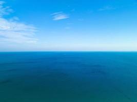 sorprendente bianca nuvole con blu cielo al di sopra di calma mare e luce del sole riflessione, aereo Visualizza Aperto mare oceano acqua superficie, soleggiato chiaro cielo e nuvole al di sopra di oceano, vivace mare con nuvole sfondo foto