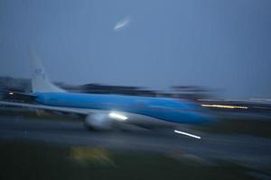 aeroporto luci nel movimento mentre aereo assunzione via a notte foto