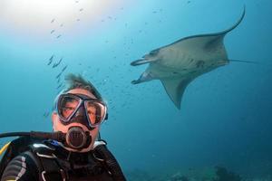 autorespiratore tuffatore e manta nel il blu oceano sfondo ritratto foto