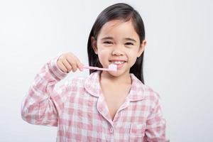 poco ragazza Asia spazzolatura denti felicemente bianca sfondo foto