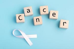 di legno bloccare con rosa nastro su blu sfondo.cervicale cancro trattamento concetto. foto