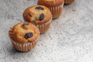 Banana cupcakes cosparso con uva passa. copia spazio su grigio sfondo. foto