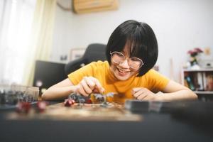 giovane adulto asiatico donna godendo ruolo giocando tavolo e tavola Giochi foto