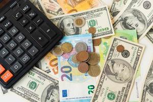 calcolatrice, Euro e dollaro banconote, monete. imposta volta, conto pagamento, calcolatrice per conteggio. foto