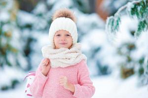 ritratto di adorabile poco ragazza andando pattinando nel inverno neve giorno all'aperto foto
