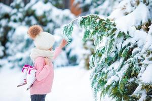 adorabile poco ragazza andando per pattinare nel caldo inverno neve giorno all'aperto foto