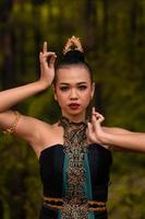 coraggioso viso di un asiatico donna nel un' tradizionale verde costume con d'oro Accessori su sua corpo durante il concorrenza nel un' danza Festival foto