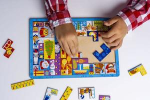 il bambino raccoglie un' puzzle. puzzle puzzle concetto di presto sviluppo. figli di mani mettere il puzzle su il tavolo foto