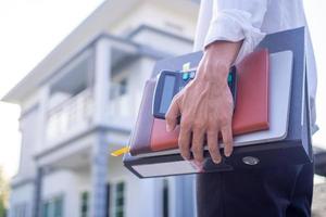 vicino su tiro di un' dell'uomo mano Tenere un' documento indietro per opera a casa. opera a partire dal casa , libero professionista concetto. sociale distanza foto